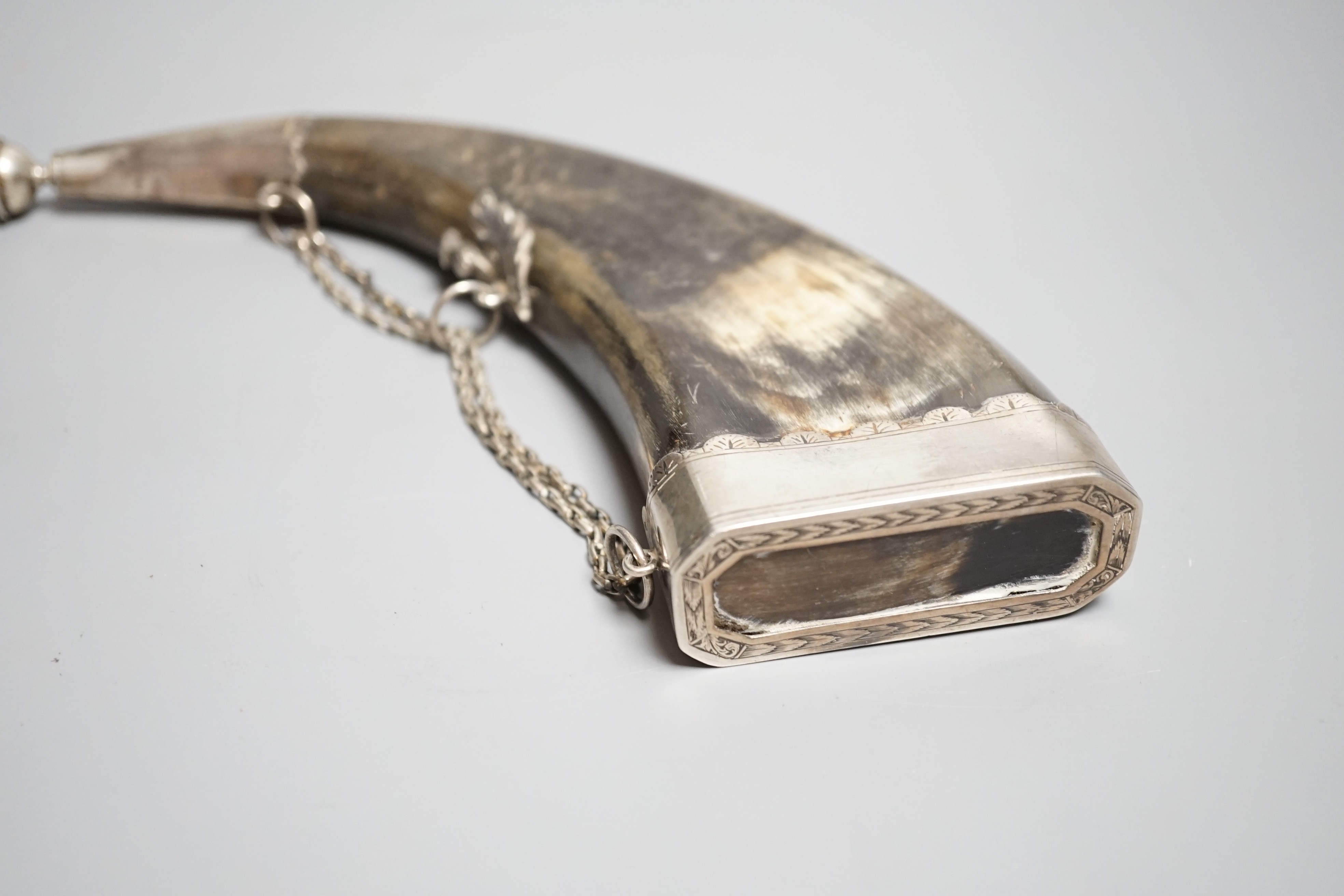 A Scottish silver mounted dress powder horn, early 19th century, engraved silver mounts (not hall marked) pierced end cap, dummy nozzle, central mount is chiseled as thistle. Length 25cms